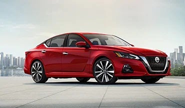 2023 Nissan Altima in red with city in background illustrating last year's 2022 model in Old Orchard Nissan in Skokie IL