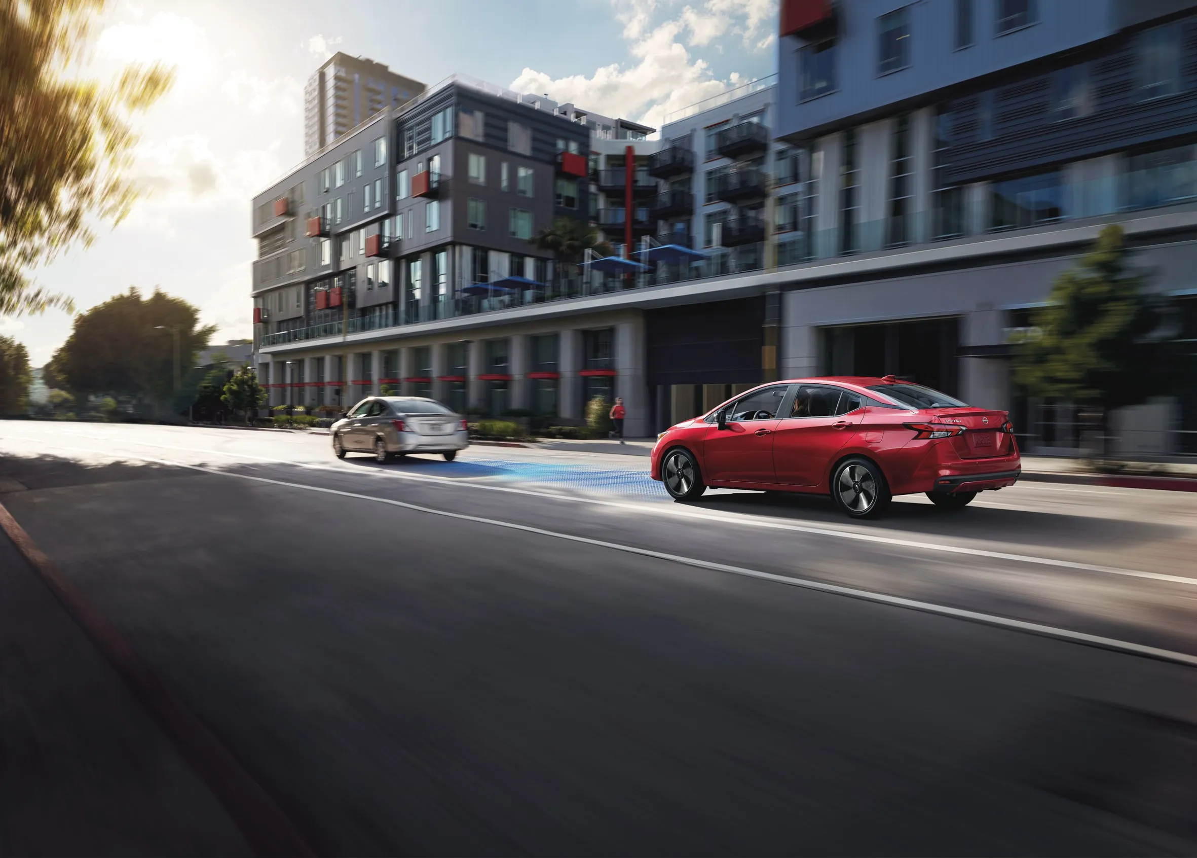 Nissan Versa Advanced Driver Assistance in Urban Traffic Red Nissan Versa using driver assist technology on city street
