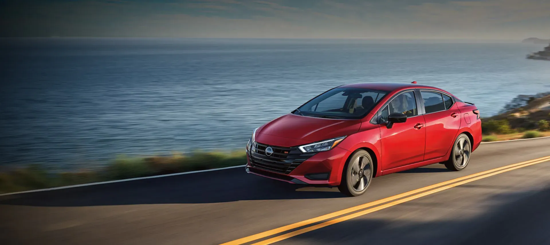 2025 Nissan Versa driving on a coastal highway