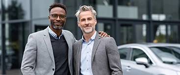 Two satisfied customers at car dealership