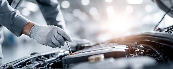 Engine Oil Inspection During Vehicle Service Mechanic checking engine oil level