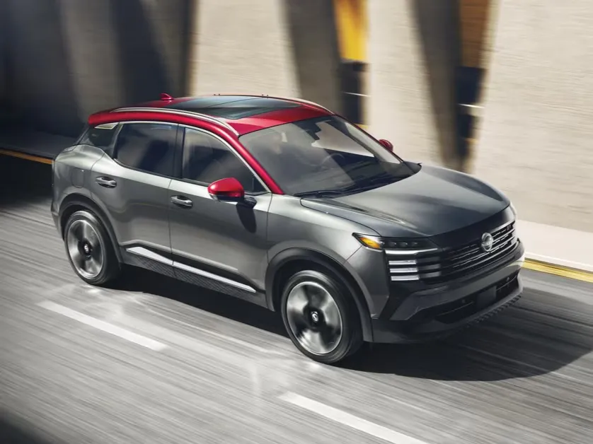 Gray Nissan SUV With Red Roof Driving on Road Gray Nissan SUV with a red roof driving on a paved road