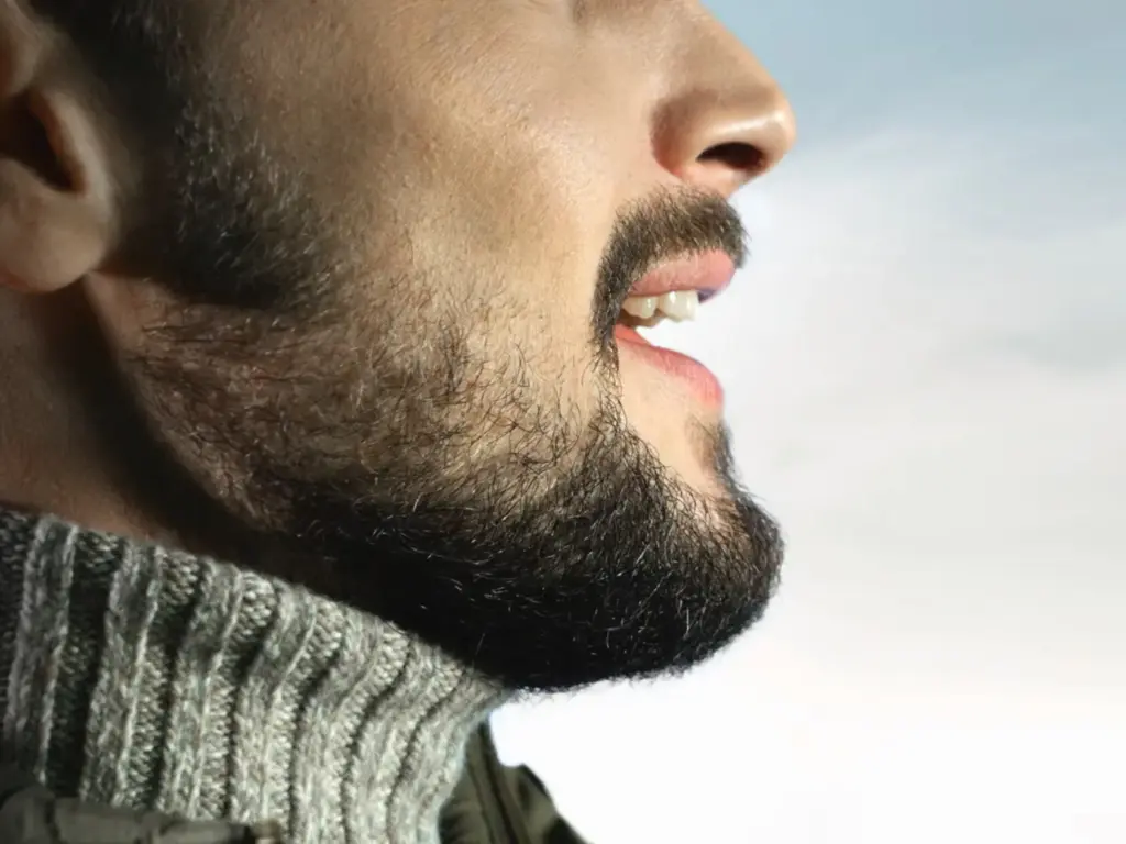 Man with Short Beard and Mustache Side Profile Side profile of a man with short beard and mustache wearing a knit collar