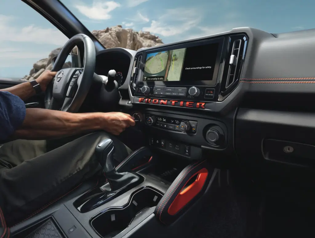 Nissan Frontier Interior Infotainment and Dashboard Controls Driver using touchscreen infotainment system in Nissan Frontier