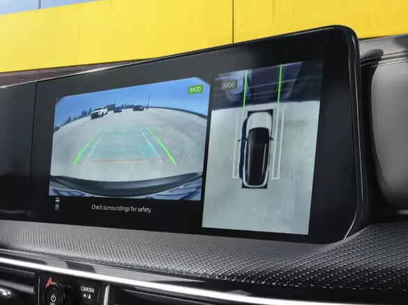 Vehicle Infotainment Screen With Rearview and Surround Camera Display Dashboard screen displaying rearview camera view and top-down surround view with parking guidelines