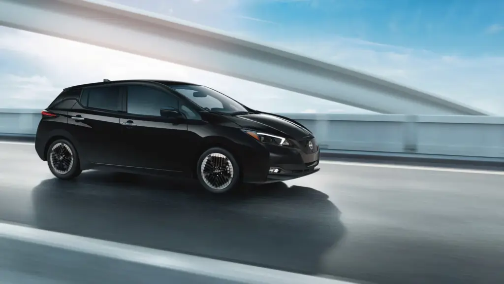 Black Nissan Leaf on Modern Bridge Black Nissan Leaf driving on modern bridge