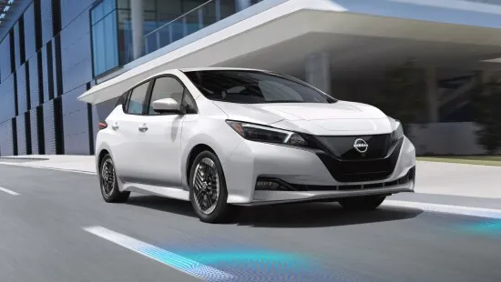 Nissan Leaf Electric Hatchback City Driving Scene White nissan leaf electric hatchback driving in city