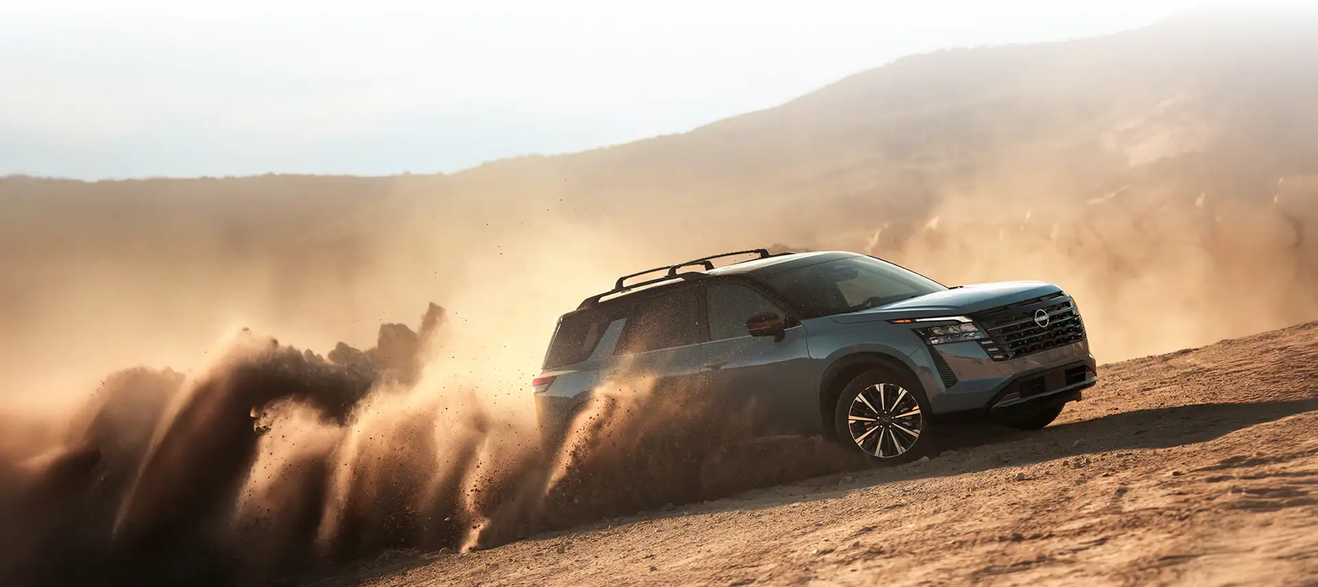 2026 Nissan Pathfinder driving off-road - front three-quarter action view