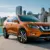 Orange Nissan Rogue SUV parked near waterfront