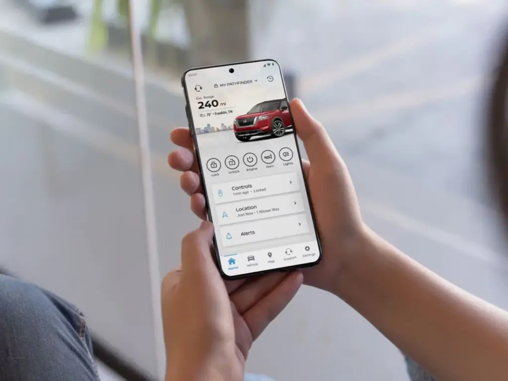 Smartphone With Vehicle Control App Interface Hands holding a smartphone displaying a vehicle control application interface