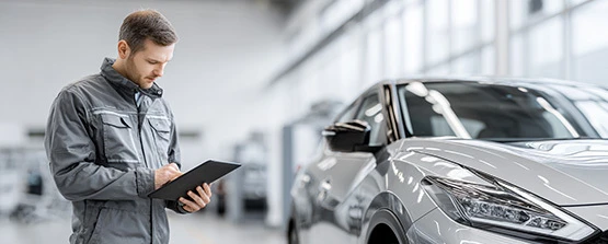 Auto Service Inspection at Nissan Dealership Center Technician inspecting car during service appointment